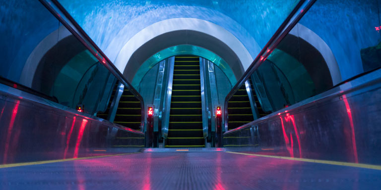 An escalator that is in a tunnel of an aquarium or body of water.