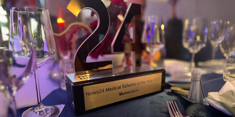 Fancy awards table setting and in the middle of the place setting is the prestigious News24 Medical Scheme of the Year Award which Momentum Medical Scheme won for the year 2025.