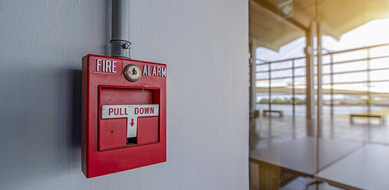 A red fire alarm on a wall, symbolising protection against fire-related risks covered by commercial insurance in South Africa.