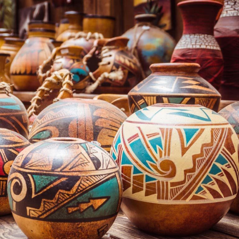 Many wooden pots with patterns in turquoise blue, cream, brown and black that are symbolic of the upcoming two pot retirement system. Your retirement savings will be split into 2 pots: a savings pot which you can withdraw from and a retirement pot.