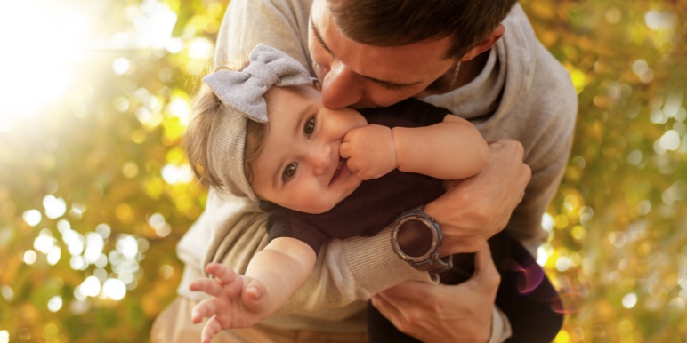 Dad playing outdoors with his young daughter