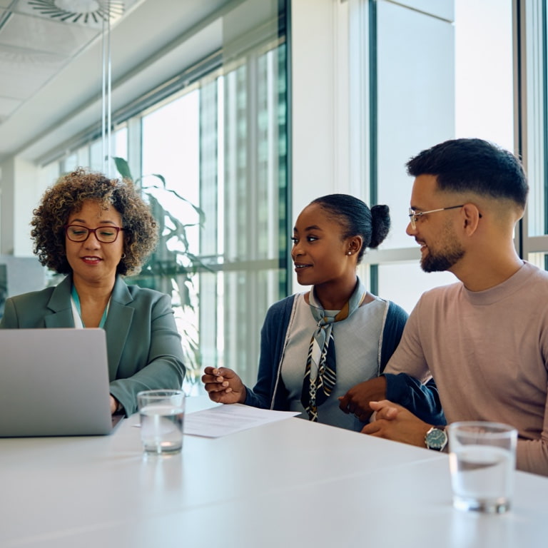 A Momentum financial adviser sits at a table with a couple, discussing their personalised financial plan together.