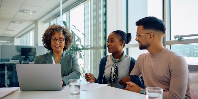 A Momentum financial adviser sits at a table with a couple, discussing their personalised financial plan together.