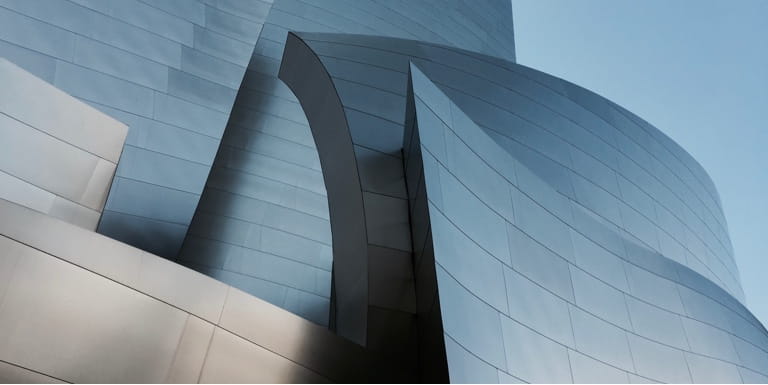A modern office building with curved, abstract grey exterior walls.