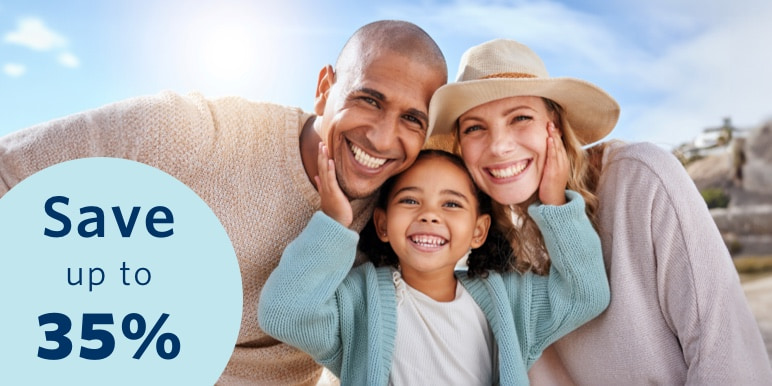 Parents enjoy a day outdoors with their young daughter. The daughter is standing in the middle of them with her hands on each parent's cheeks.