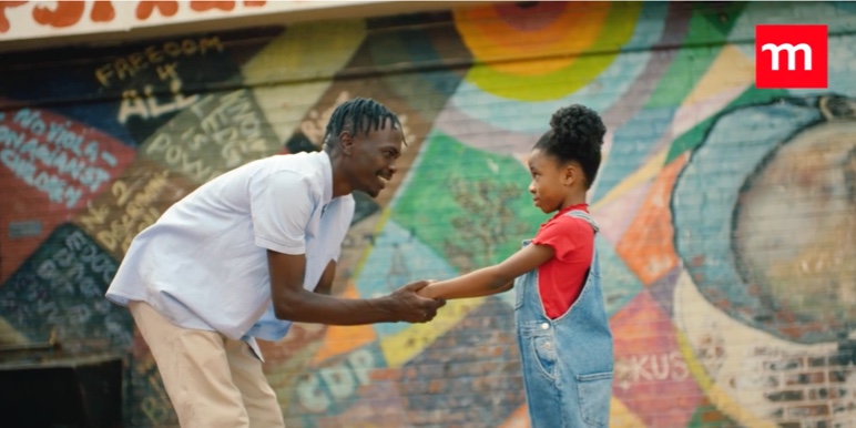 A UNICEF caregiver greeting a young girl at a Safe Park.