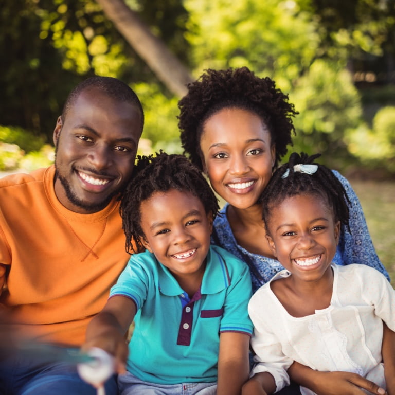 Mom and dad spending time outdoors with their two young children.