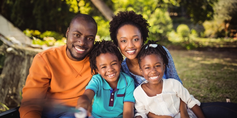 Mom and dad spending time outdoors with their two young children.