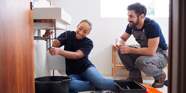 A Momentum Insure client with home insurance receiving plumbing emergency assistance from a Momentum Assist agent after their bathroom basin's tap burst.