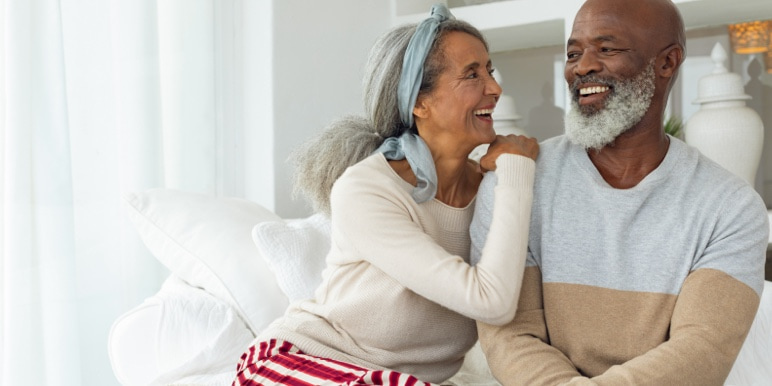 A happy, retired couple laughing together.