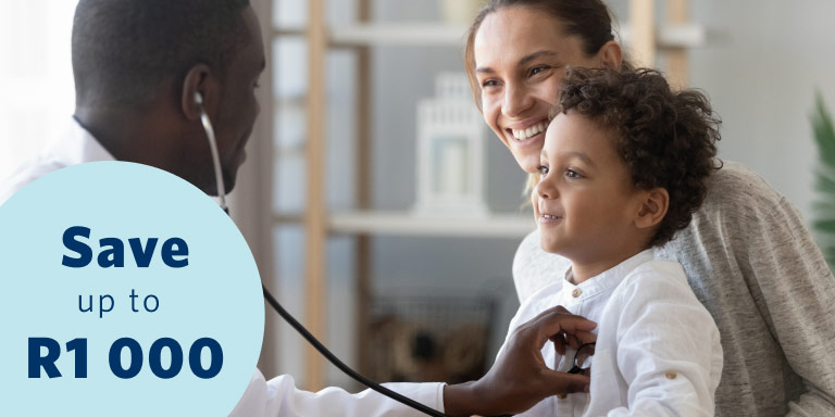 A content little boy sitting on his mother’s lap gets his chest examined by a young male doctor using a stethoscope.
