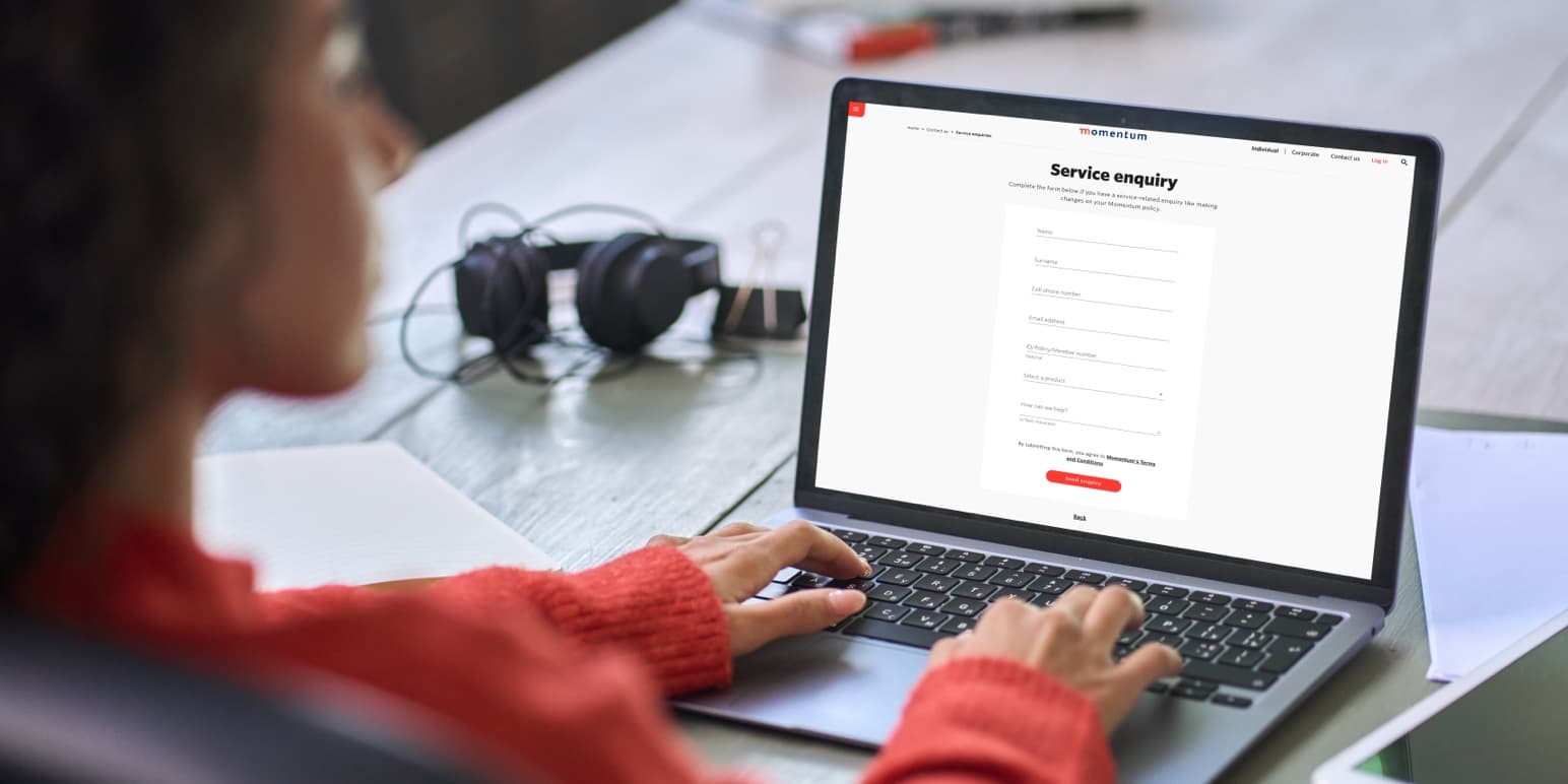 A lady typing on her laptop filling in an enquiry form to get a call back from a financial adviser from Momentum Financial Planning.