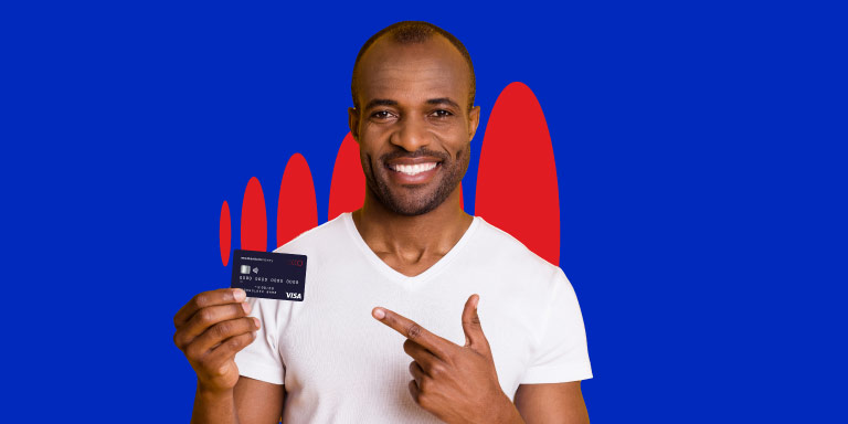 A young man is holding his HealthSaver card in one hand and pointing with his other hand to the card while smiling as he know he can use his funds in his HealthSaver account to pay for things.